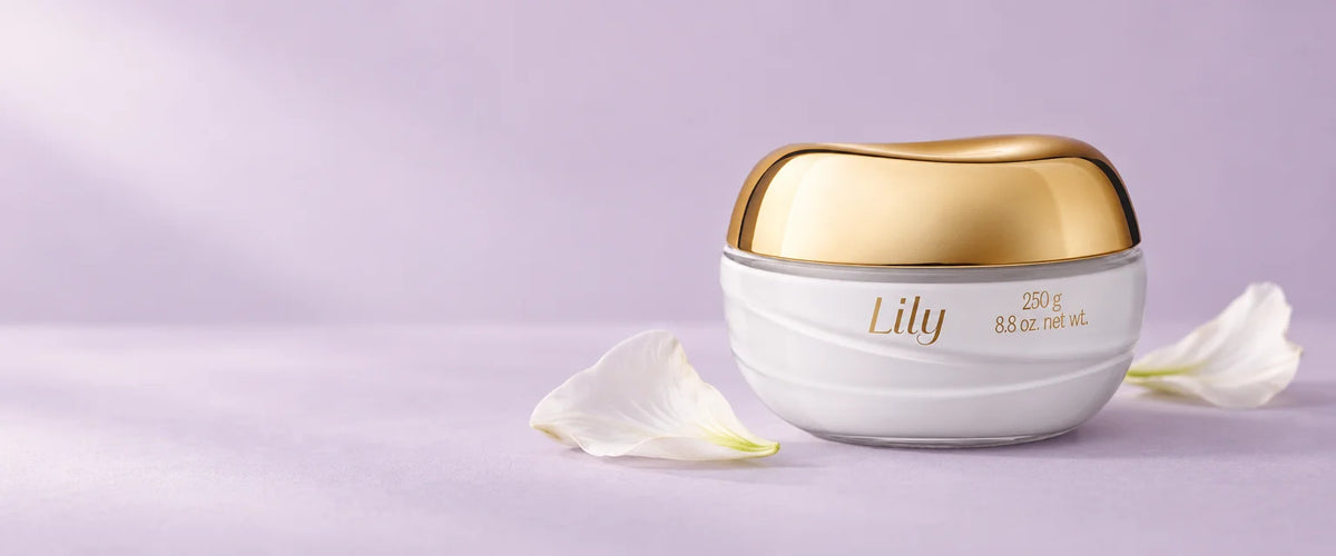 Crema Corporal Acetinado Lily sobre fondo lila con pétalos de lirio
